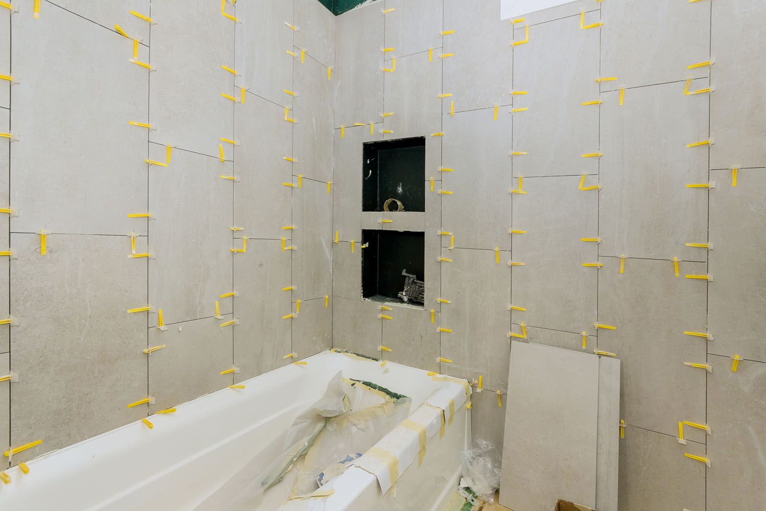 Laying tiles in the bathroom construction floor and wall ceramic tiles installation unfinished apartments