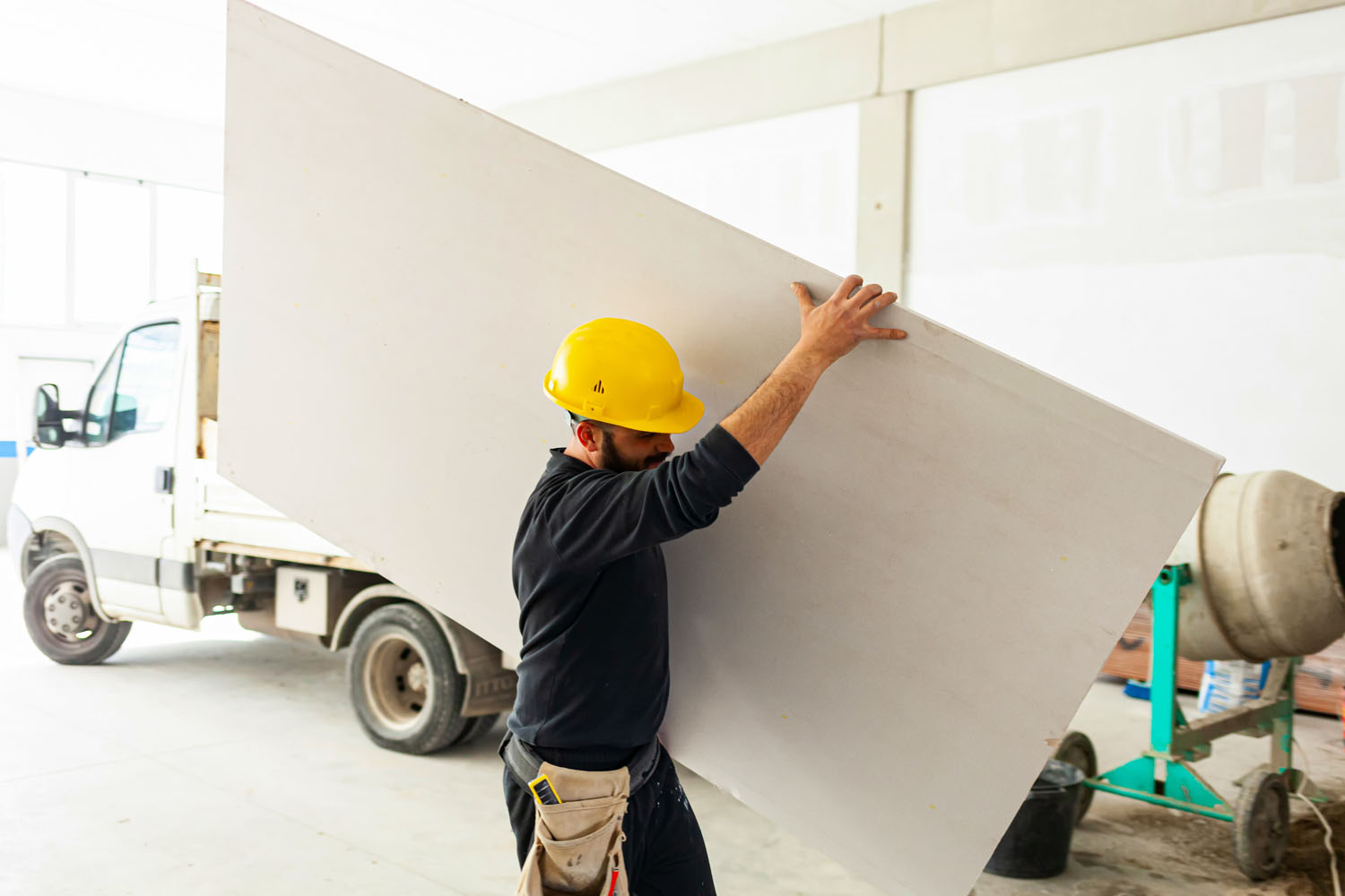 Worker at work in the construction of a plasterboard wall.